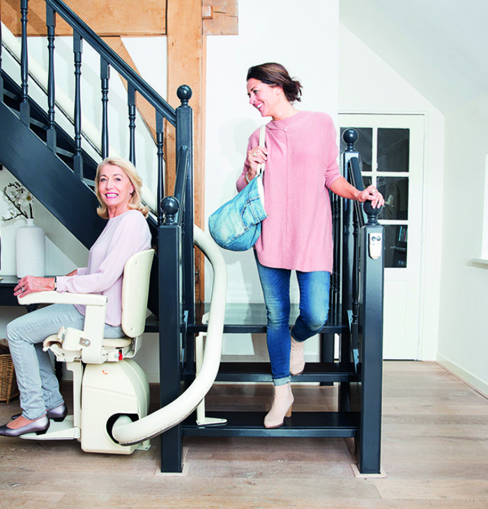 Woman riding a handicare freecurve stairlift